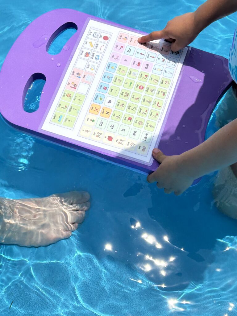 Child pointing to an icon on a communication display attached to a kick board.
