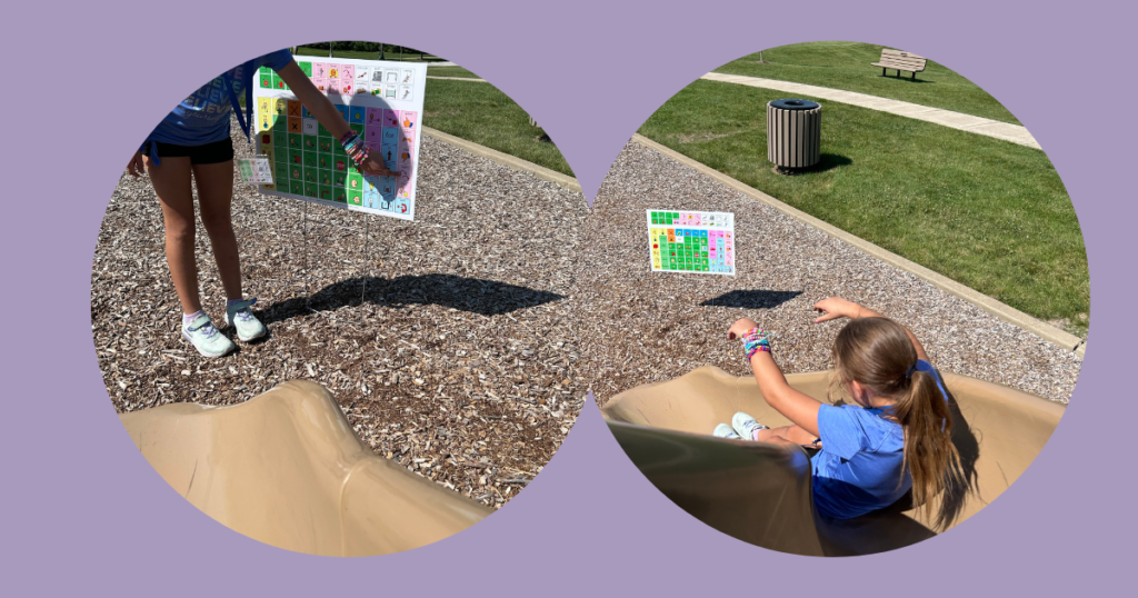 Child is sliding down a slide. A yard sign communication board is at the bottom of the slide.