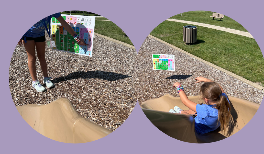 Child is sliding down a slide. A yard sign communication board is at the bottom of the slide.