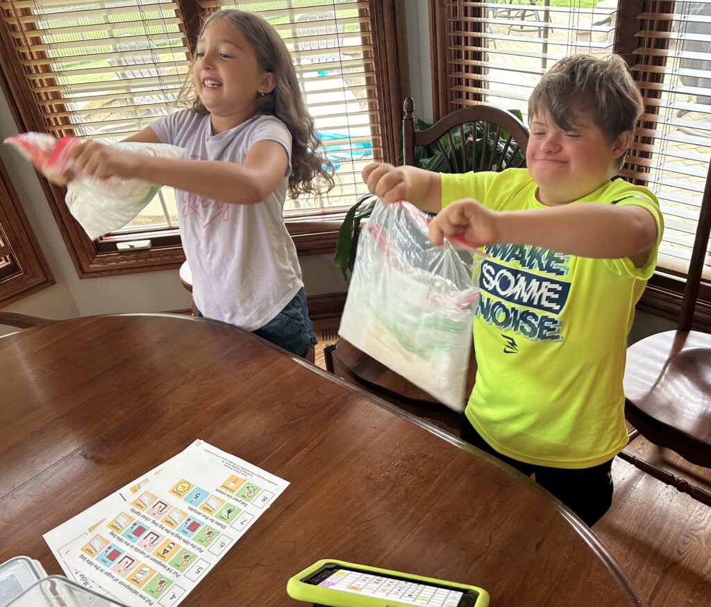 Young girl and boy shaking baggies filled with ice to make ice cream.